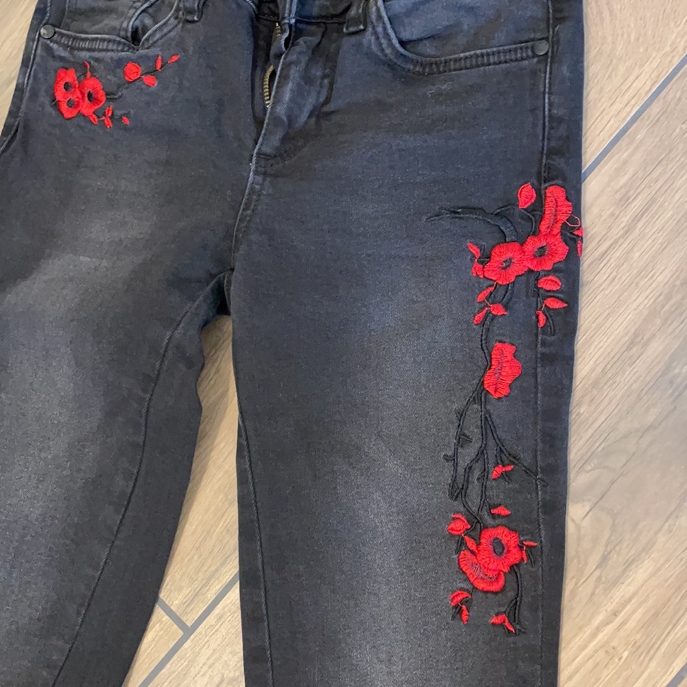Black jeans with embroidered red flowers